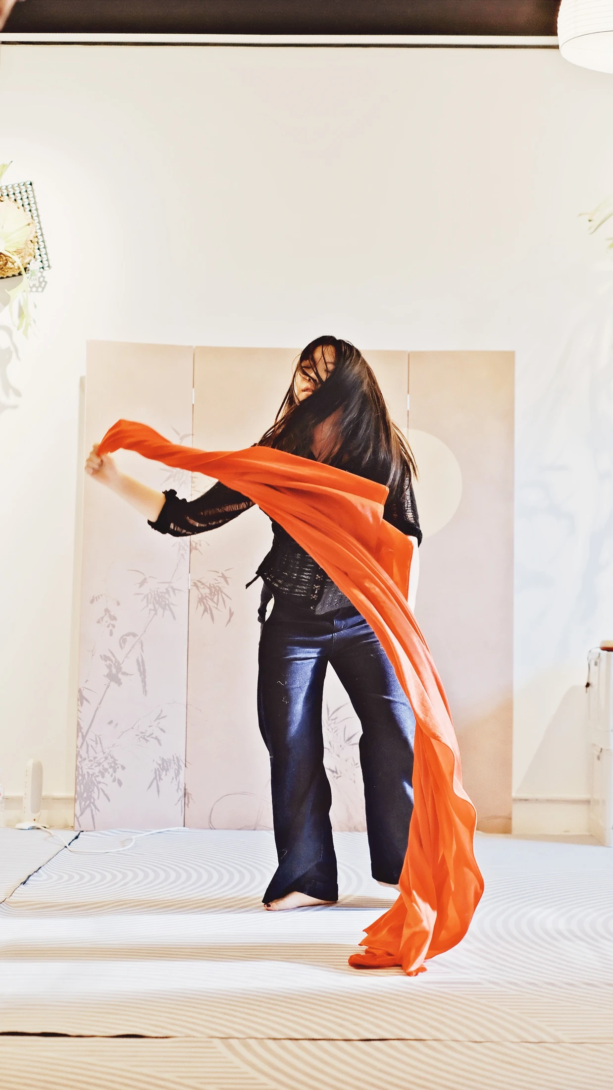 A participant exploring expressive movement with flowing red fabric