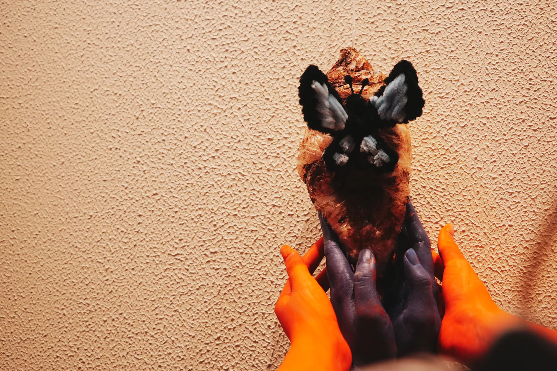 A tactile handmade sculpture held by participants with painted hands